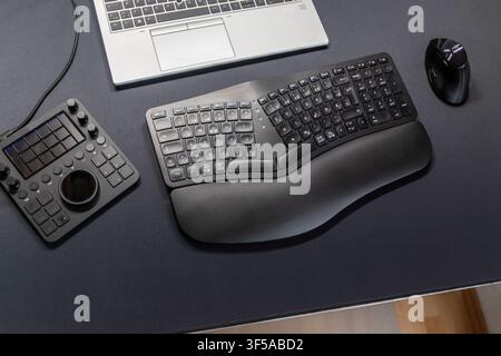 Ergonomic keyboard and ergonomic mouse as ergonomic home office equipment for freelance work and healthy workplace for notebook and clean desktop Stock Photo