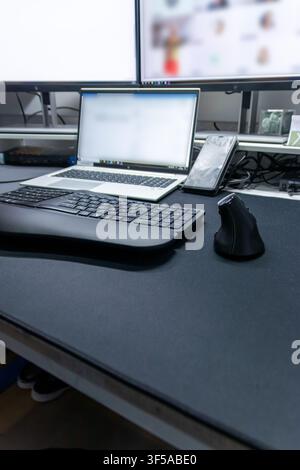 Ergonomic keyboard and ergonomic mouse as ergonomic home office equipment for freelance work and healthy workplace for notebook and clean desktop Stock Photo