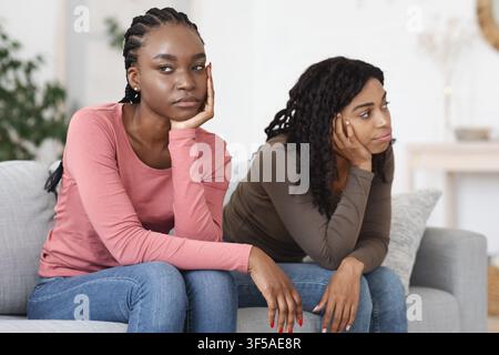 Two upset african women sitting on sofa, had quarrel Stock Photo