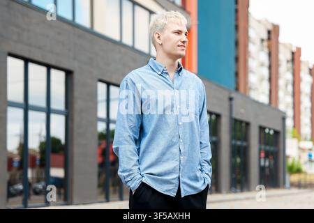Smiling man in shirt outdoors, low angle view Stock Photo