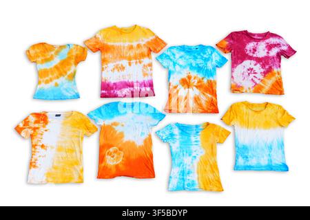 Colorful hand-dyed tie dye t-shirts with vibrant spiral and striped patterns displayed flat lay on a dark asphalt background during a summer creative Stock Photo