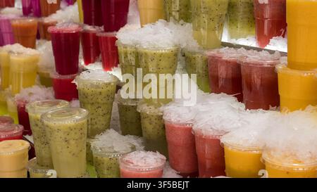 Colourful fresh fruit juices packed in ice at a market stall, close-up drink display — concept: healthy drinks, fresh juice bar, summer refreshment Stock Photo