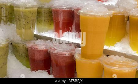 Colourful fresh fruit juices packed in ice at a market stall, close-up drink display — concept: healthy drinks, fresh juice bar, summer refreshment Stock Photo