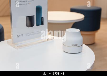 Kremenchuk, Ukraine - November 29, 2019: Minimalist White Electronic Device of Iqos On Round Table In Modern Interior With Product Display Signage Stock Photo