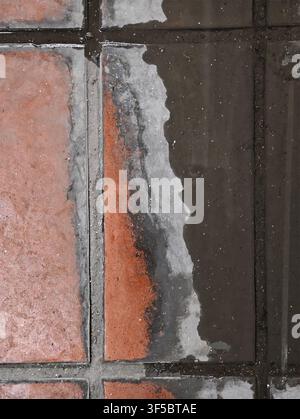 Puddle on brick pavement reflecting surface, in outdoor urban environment, with brick tiles, pavement, from a top-down perspective perspective, with b Stock Photo