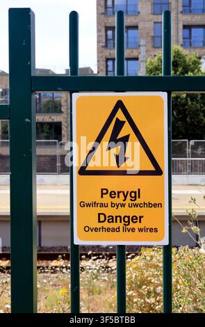 Bilingual danger sign - Danger Overhead live wires - Perygl gwifrau byw uwchben. Cardiff Bay new train station, Cardiff Stock Photo