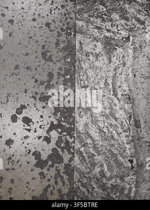 Two adjacent concrete panels form strong vertical seam, displaying mottled gray texture with dark stains, chips, scratches, rough grain, and worn indu Stock Photo