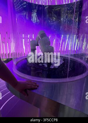 industrial robotic arm playing chess inside a transparent display at an interactive technology exhibition. artificial intelligence, automation, roboti Stock Photo