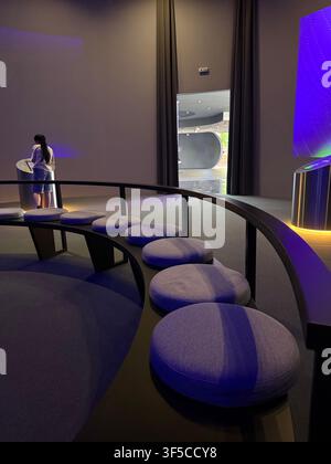 modern technology exhibition interior featuring interactive touchscreen kiosks, curved seating and minimalist architectural design. futuristic museum Stock Photo