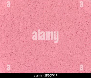 light pink sponge texture background, porous foam surface with tiny bubbles and holes, macro close-up view, abstract cleaning material Stock Photo