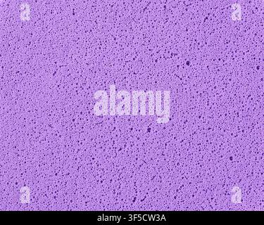 purple sponge texture background, porous foam surface with tiny bubbles and holes, macro close-up view, abstract cleaning material Stock Photo