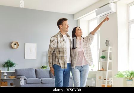 Happy couple planning interior decoration or home layout standing in living room. Stock Photo