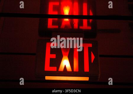 Illuminated sign indicating the exit in backlit red letters Stock Photo