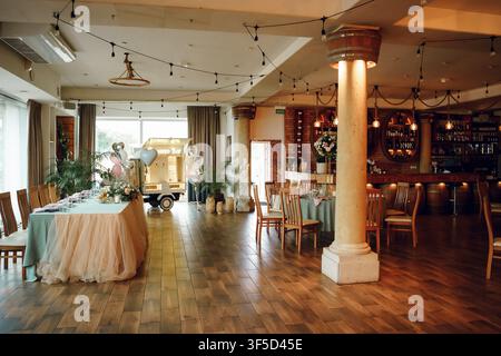 Elegant wedding reception hall with tulle table decor, warm fairy lights, and wooden floors, perfect for event planning and banquet imagery, ideal for banquet planning Stock Photo
