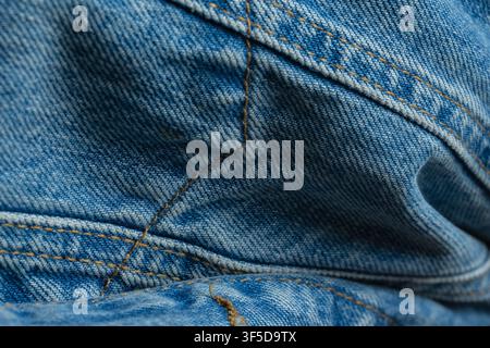 Abstract background showing blue denim textile with visible seams and threads Stock Photo