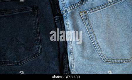 Close-up of two different colored denim jeans showing fabric textures and stitching Stock Photo
