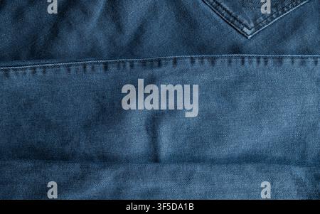 Blue indigo denim fabric showing detailed texture and stitching for a background Stock Photo