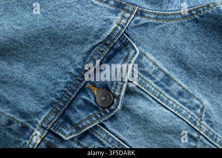 Blue denim fabric showing texture, stitching, pockets, and a button Stock Photo