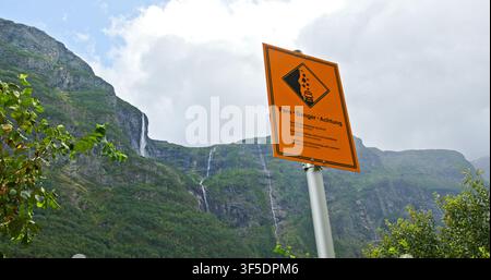 Norway falling rocks danger sign with waterfalls and mountains Stock Photo