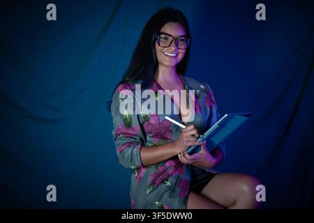 Smiling woman using tablet creating digital artwork Stock Photo