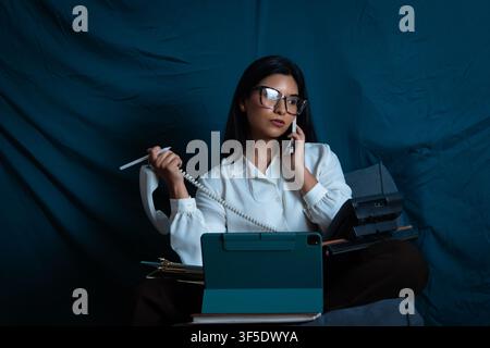 Woman multitasking, managing multiple calls and devices Stock Photo