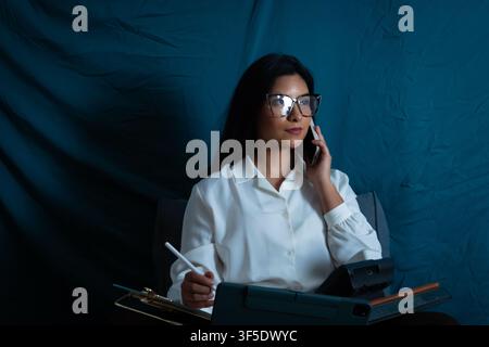 Businesswoman talking on phone working with tablet Stock Photo
