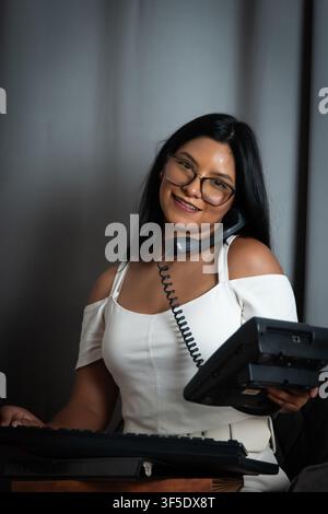 Smiling woman providing customer service assistance on telephone Stock Photo