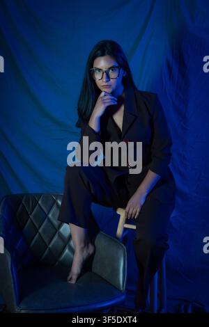 Woman in suit and glasses posing with confidence Stock Photo