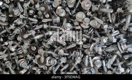 Texture of small bolts and nuts in bulk. Stock Photo