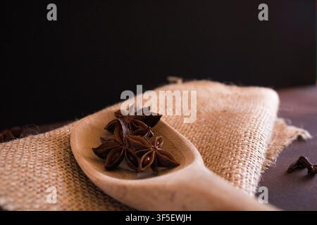 star anise in a spoon on a sackcloth Stock Photo