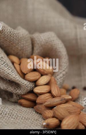 spilled almonds in burlap bag Stock Photo