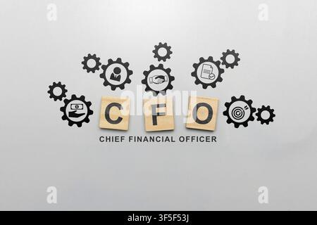CFO Chief Financial Officer concept shown with wooden blocks and business gear icons representing strategy, finance, and management on a grey backgrou Stock Photo