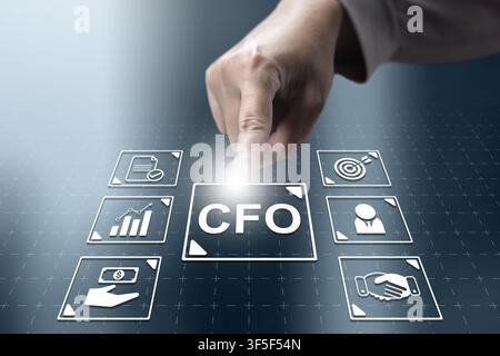 Businessman interacting with a futuristic digital interface featuring the CFO title and corporate icons for financial management, strategy, and leader Stock Photo