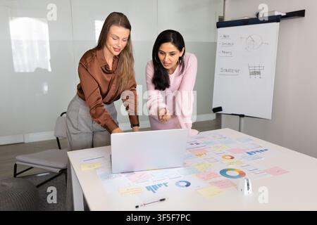 Business colleagues discussing marketing strategy using laptop in office Stock Photo