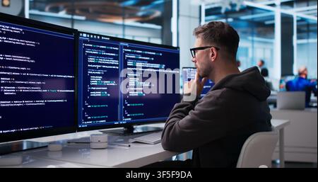 Young Software Engineer Coding Secure Business Platform At Modern Office Desk. Stock Photo