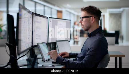 Young Software Engineer Works On Laptop Creating AI-powered Knowledge System. Stock Photo
