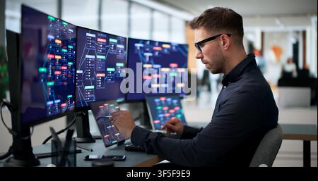 Young Man Uses Laptop And Tablet To Build Digital Business Workflows Rapidly. Stock Photo