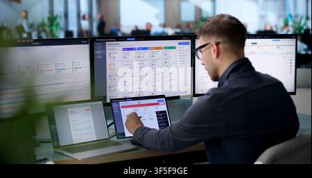 Man Uses Laptop To Monitor Live Business Dashboard Ensuring Smooth Operations. Stock Photo