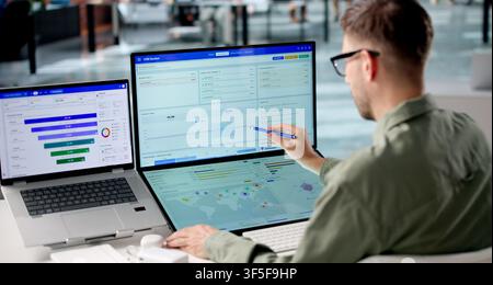 Man Analyzes Sales Data On Laptop Using CRM Software For Marketing Growth. Stock Photo