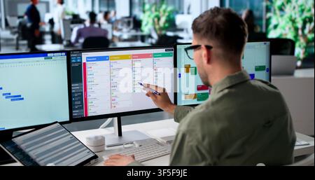 Agile Project Manager Updates Digital Scrum Board Tasks Using Laptop Screen. Stock Photo