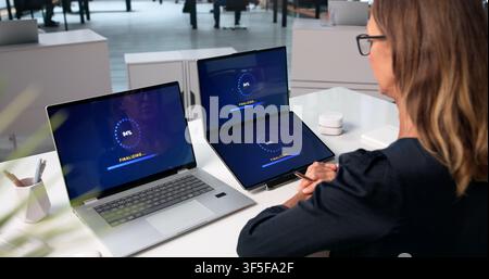 Woman Is Installing A New Software Update On Her Laptop Screen. Stock Photo