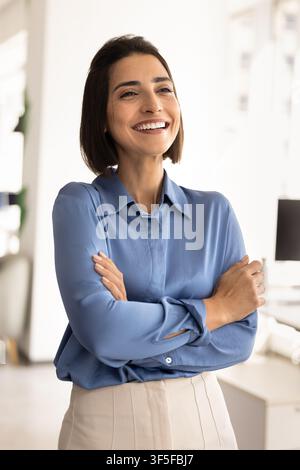 Portrait of confident businesswoman stands with folded arms in office Stock Photo