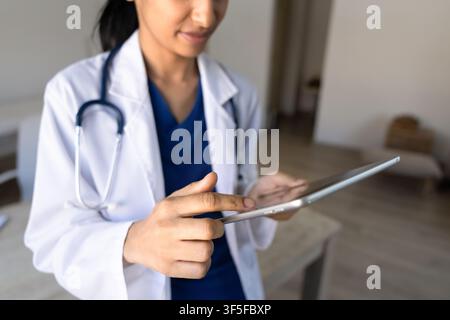 Closeup female doctor working on digital tablet in clinic office Stock Photo