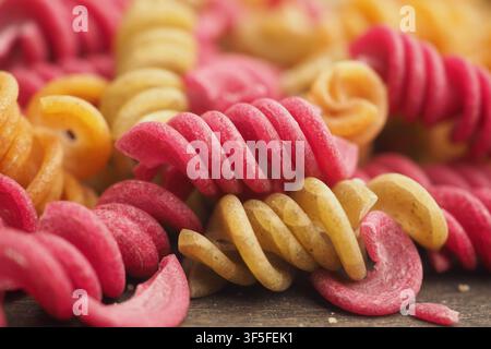 Colorful pasta shapes on a wooden table during the day Stock Photo