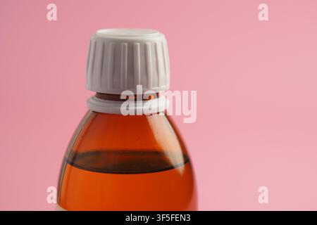 Bottle of liquid with white cap on pink background Stock Photo