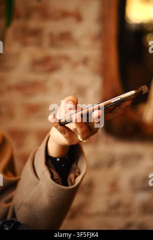 Person holding smartphone in indoor setting Stock Photo