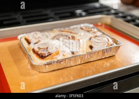 Freshly Baked Cinnamon Rolls Cooling on Stove Top Stock Photo