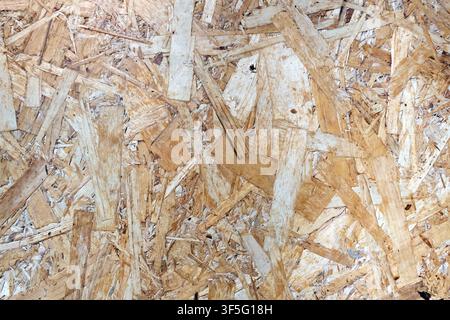 Background showing texture of oriented strand board panel OSB. Compressed wood shavings and chips create unique patterns. Perfect material for constru Stock Photo