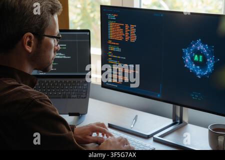 Focused coder using AI assistant to write programing code on computer at desk with dual screens, boosting productivity and automation with artificial intelligence agents and AI chatbots. Copy space Stock Photo