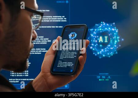 Close up of man holding a smartphone with an AI chatbot app against a glowing visualization displaying artificial intelligence software interface on background. Ai assistant application. Copy space Stock Photo